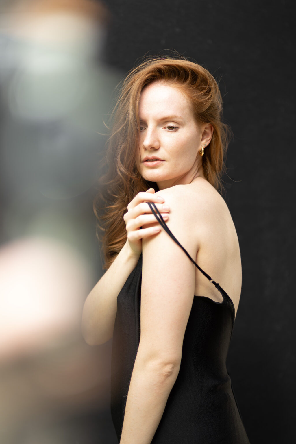 Junge Frau mit roten Haaren im schwarzen Kleid