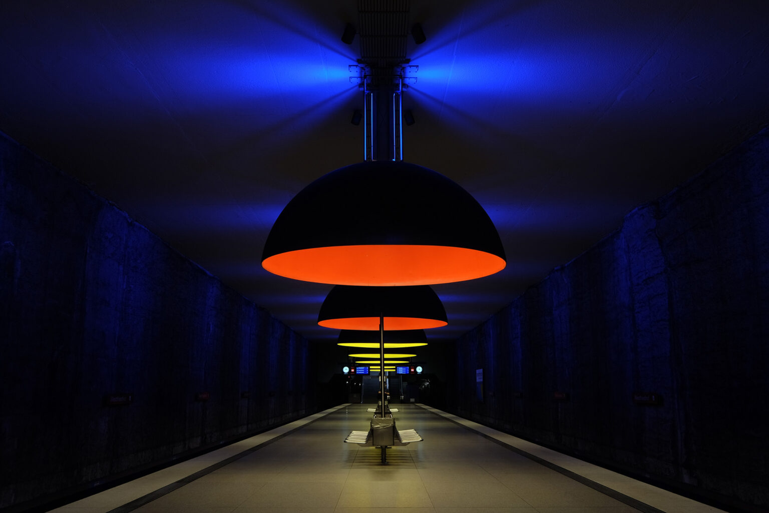 U-Bahnhof mit blauen Wänden und roten Hängelampen