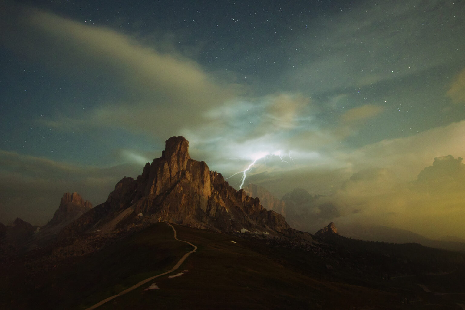 Berggipfel im Abendlicht mit Blitz am Himmel