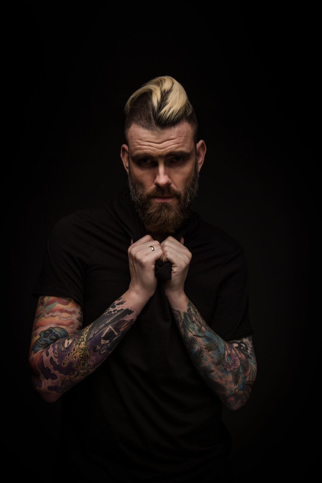 Low-Key-Portrait eines tätowierten Mannes im Hochformat